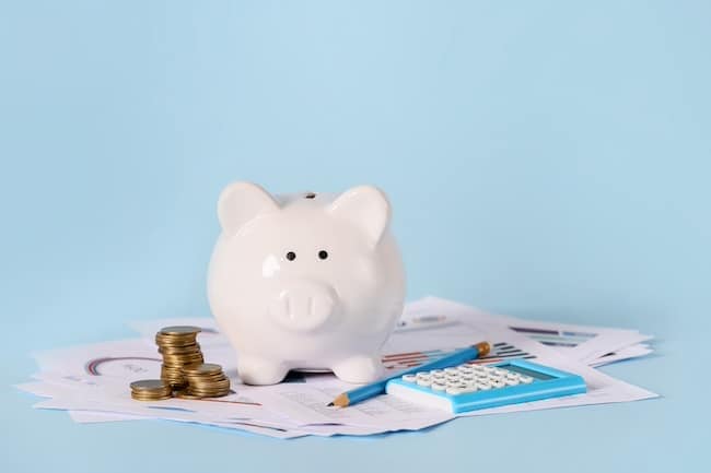 Piggy bank with savings, calculator and documents on color background. Concept of pension