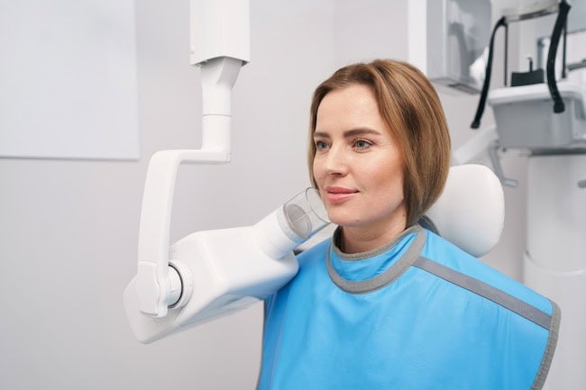Woman sitting near dental scanning machine in clinic